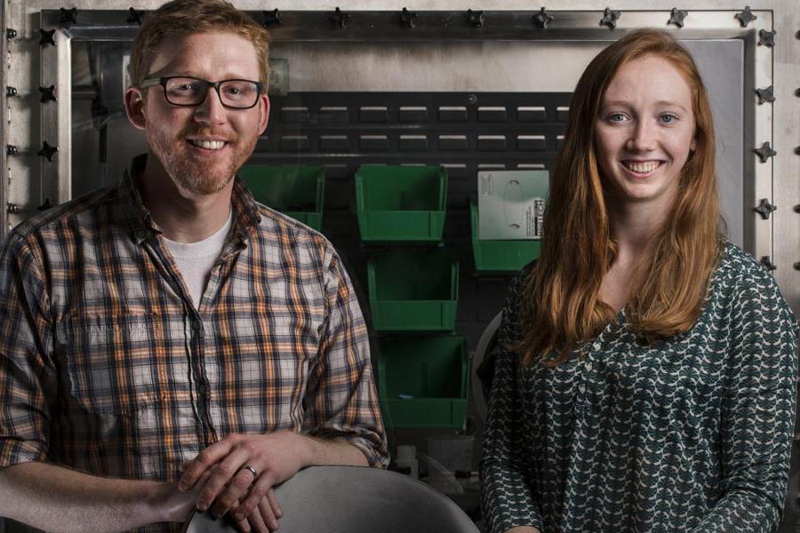 Two people smile at the camera.